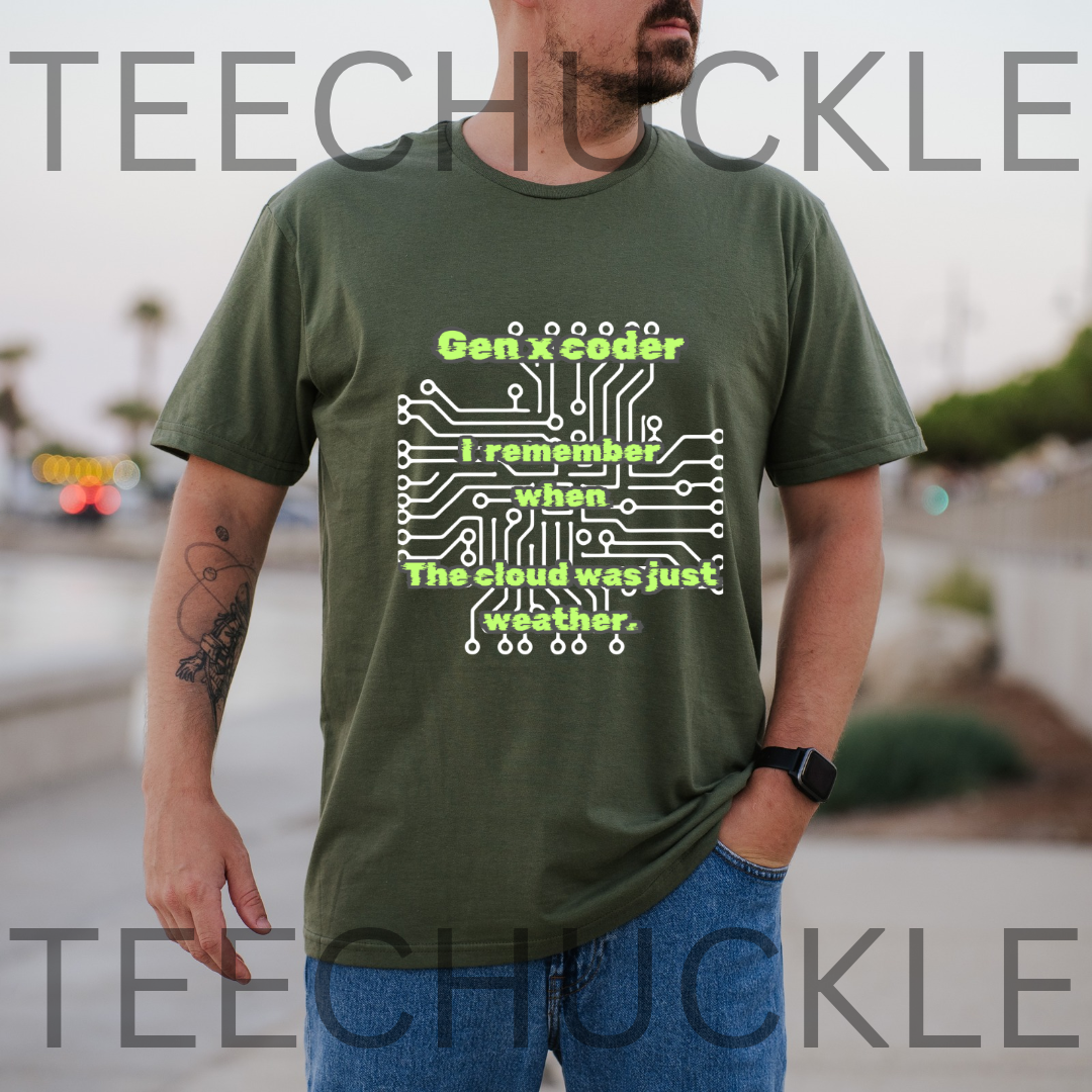 A man wearing a green graphic t-shirt with a white and lime green circuit board design and the text 'Gen x coder I remember when The cloud was just weather.' The image  background is a blurred outdoor street scene.