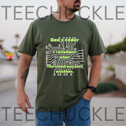 A man wearing a green graphic t-shirt with a white and lime green circuit board design and the text 'Gen x coder I remember when The cloud was just weather.' The image  background is a blurred outdoor street scene.