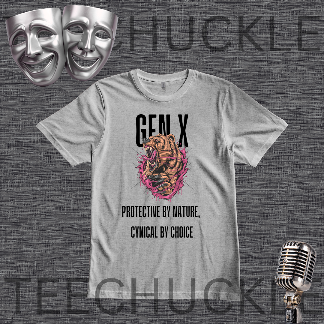 A gray graphic t-shirt featuring a roaring tiger illustration with pink and orange accents, and the text 'GEN X' and 'PROTECTIVE BY NATURE, CYNICAL BY CHOICE'. The t-shirt is displayed on a dark gray textured background with decorative props including two silver theater masks, a vintage microphone
