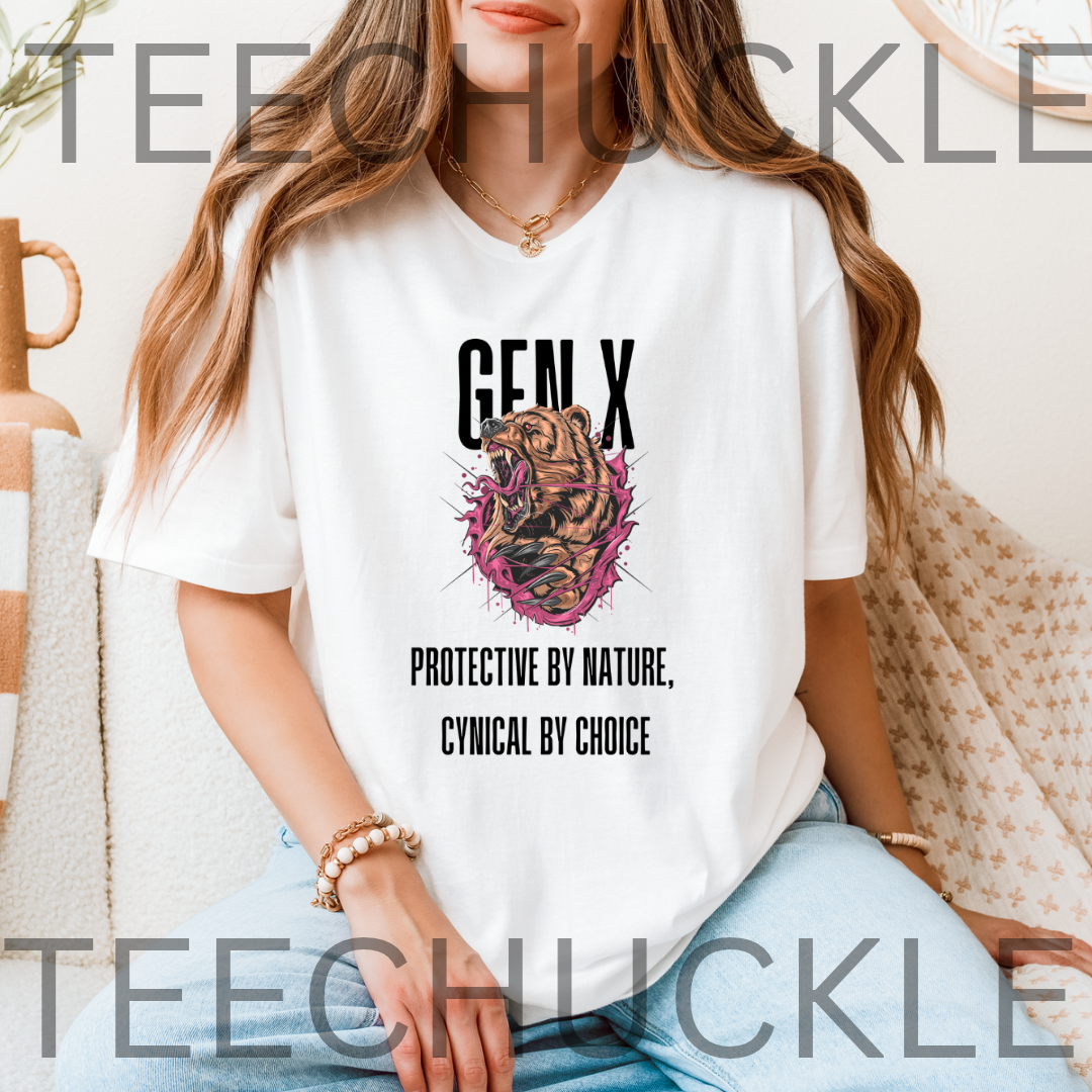 A woman wearing a white graphic T-shirt with the text 'GEN X' and 'PROTECTIVE BY NATURE, CYNICAL BY CHOICE' around a bear illustration. The photo is taken in a cozy indoor setting 