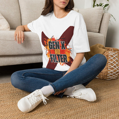 A woman sitting cross-legged on a woven rug in front of a beige sofa, wearing a white graphic T-shirt with a large red and orange 'X' design and the text 'GEN X NO FILTER' in black