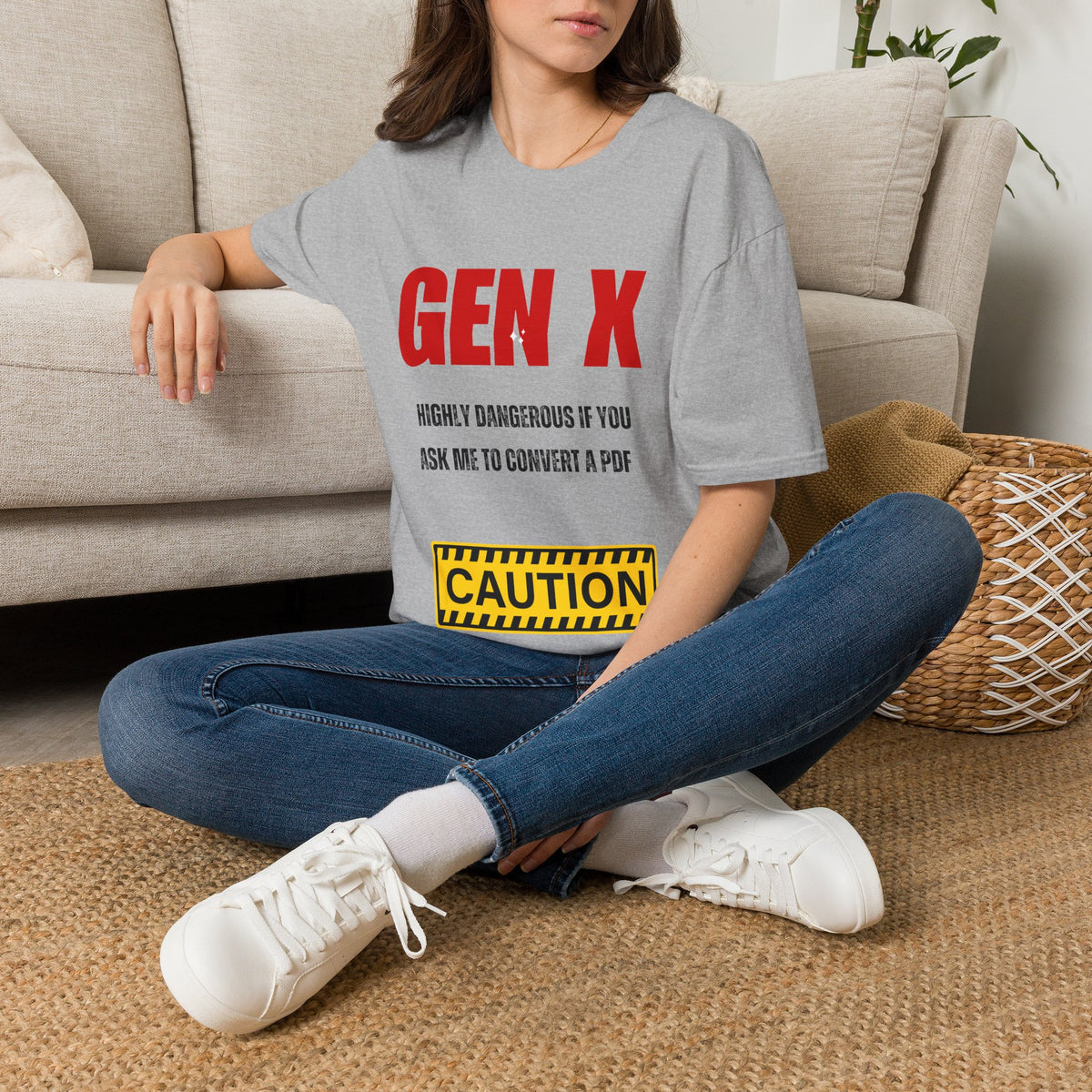 A grey graphic t-shirt. The shirt features the text 'GEN X' in bold red letters, followed by 'HIGHLY DANGEROUS IF YOU ASK ME TO CONVERT A PDF' in black, and a yellow 'CAUTION' warning label graphic.