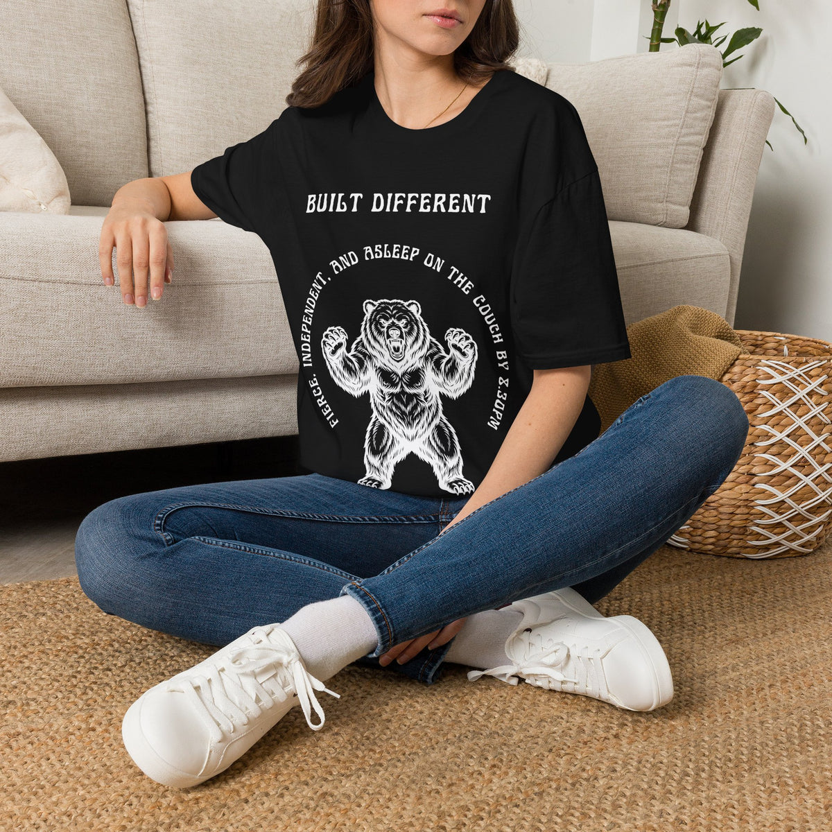A white short-sleeve graphic t-shirt  The t-shirt features a black graphic of a roaring bear with the text 'MY BACK IF I SLEEP WRONG' and 'BUILT DIFFERENT' above it.