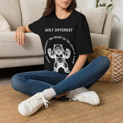 A white short-sleeve graphic t-shirt  The t-shirt features a black graphic of a roaring bear with the text 'MY BACK IF I SLEEP WRONG' and 'BUILT DIFFERENT' above it.