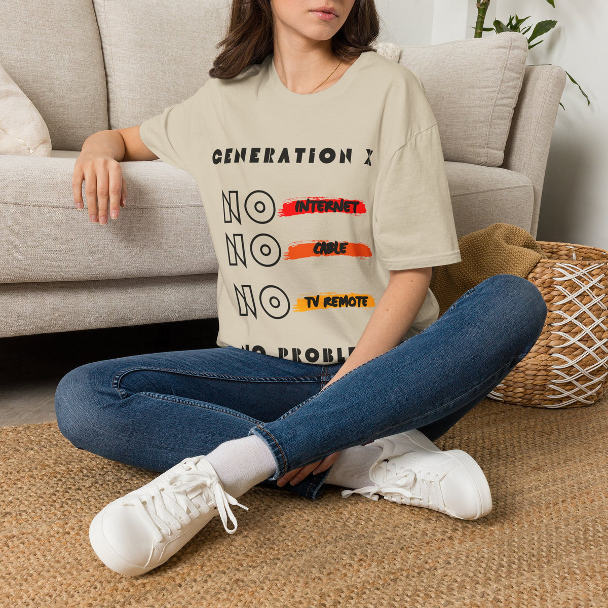 Lady wearing a sand t-shirt with 'GENERATION X NO INTERNET NO CABLE NO TV REMOTE NO PROBLEM' design sitting on the floor.