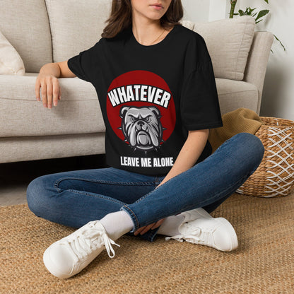 A black short-sleeve graphic t-shirt displayed on a gray wood plank background, featuring a red circular graphic with a bulldog and the text 'WHATEVER LEAVE ME ALONE'. The image includes decorative props like silver theater masks and a vintage microphone